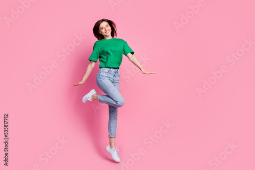 Full length photo of overjoyed pretty person jumping have good mood isolated on pink color background