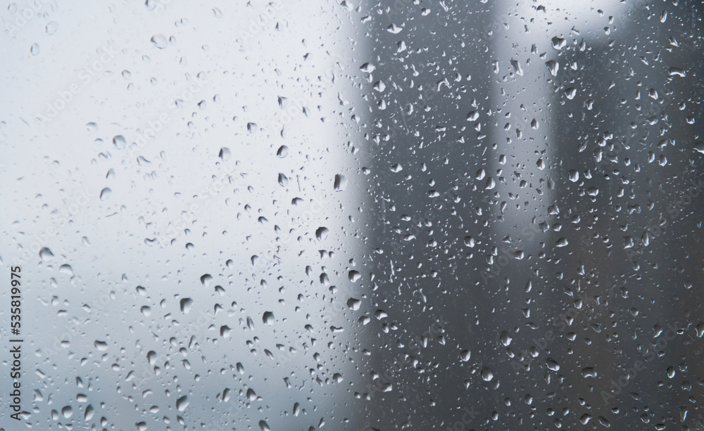 City buildings through a window with water drops