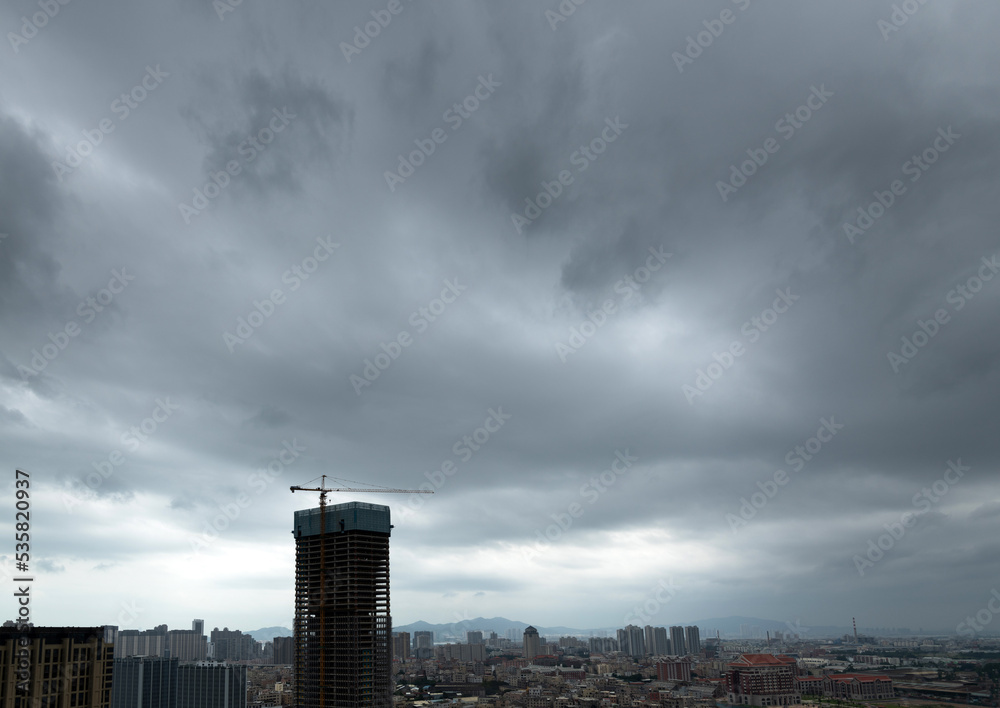 Obraz premium Unfinished building under dark clouds