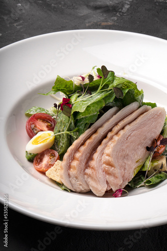 Salad with chicken fillet and vegetables on a white plate