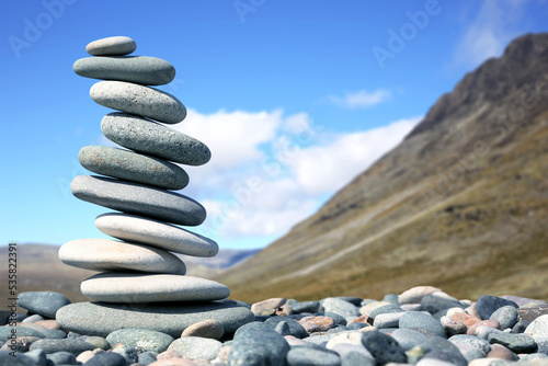 pyramid of smooth stones on the background of a mountain. natural balance of life.