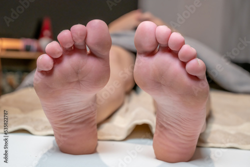 dessous de pieds d'une jeune femme allongé sur une table de soins esthétiques photo