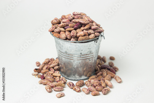 Fototapeta Naklejka Na Ścianę i Meble -  Small steel bucket with beans on a white background. Dried beans
