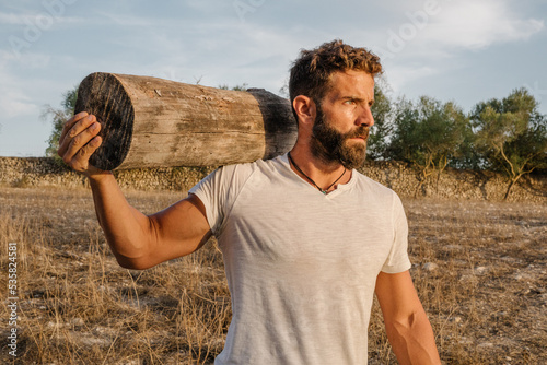 Strong male farmer with log photo