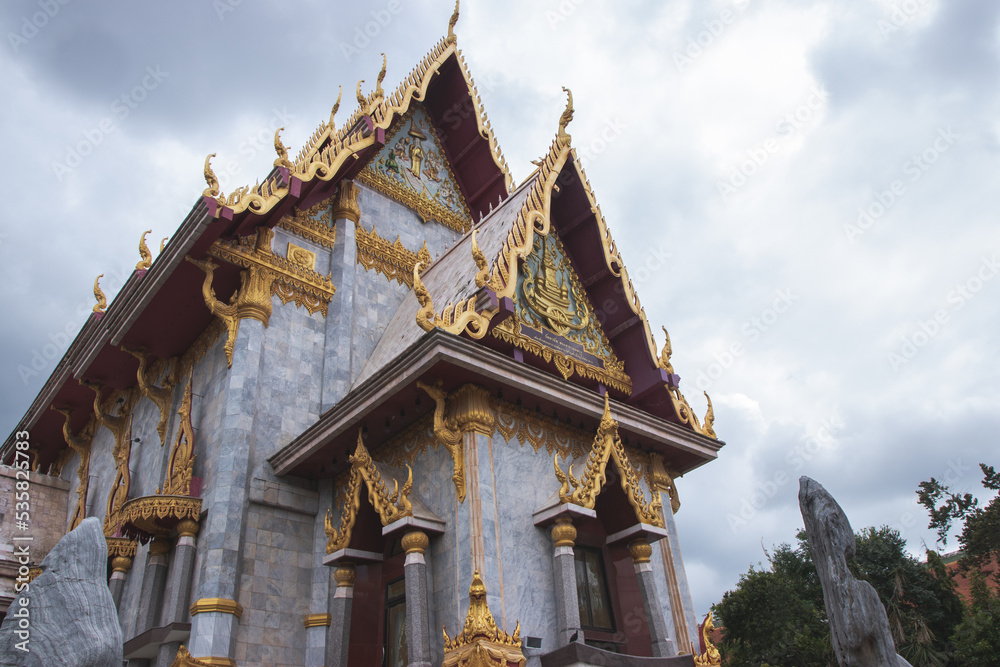 Fototapeta premium Golden pagoda in Northeastern of Thailand, Pagoda is on rainy cloud background.