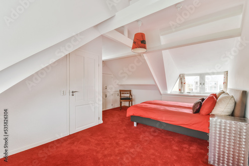 single bed placed over red carpet in a modern bedroom photo