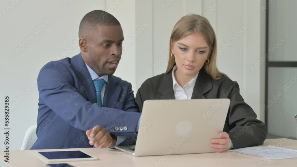 Young Business People Discussing Work on Laptop Young Business People Discussing Work on Laptop