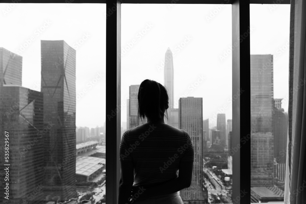 Fototapeta premium Woman standing in front of the window
