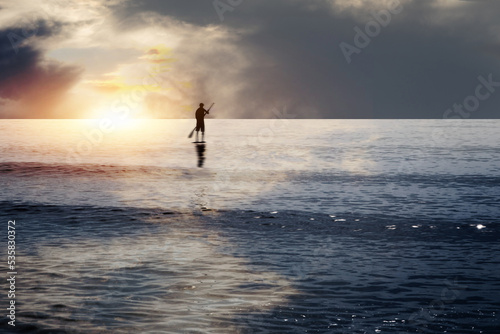 Ein junger Mann auf einem Surfbrett genießt den Sonnenuntergang am Meer