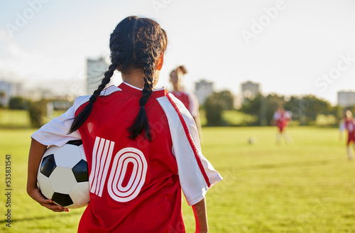 Children, sport and football with a girl soccer player on a field outdoor for fitness, exercise or training. Sports, workout and kids with a female child on grass for health, wellness and recreation photo