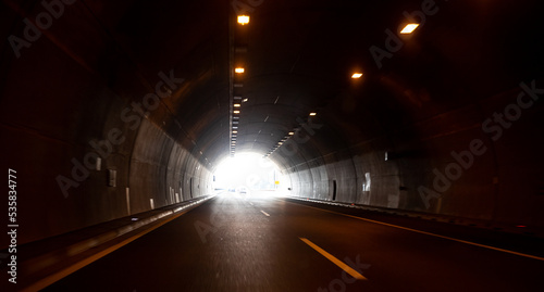 Dark tunnel on highway with the light in the end