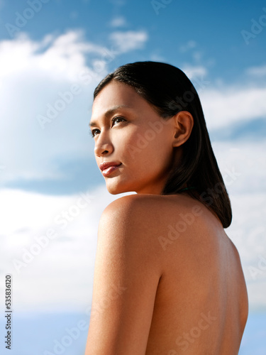 Portrait of young Balinese woman on a beach at dawn. Sanur, Bali, Indonesia.