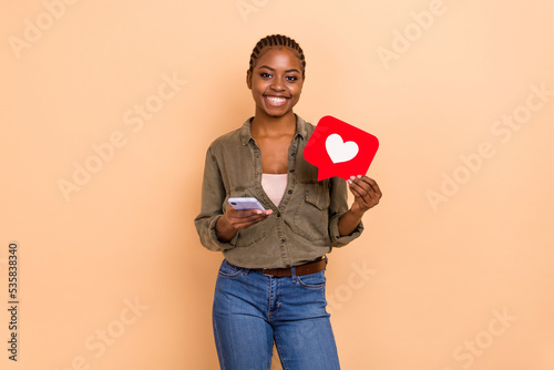 Photo of attractive cheerful girl hold telephone paper like card toothy smile isolated on beige color background