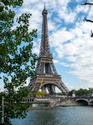 Eiffel tower across Seine River through trees