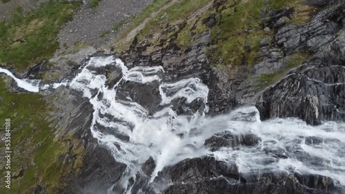 Drone diving out from cliff and following mountain waterfall fjellfossen above Eidslandet and Leiro in Vaksdal Norway photo