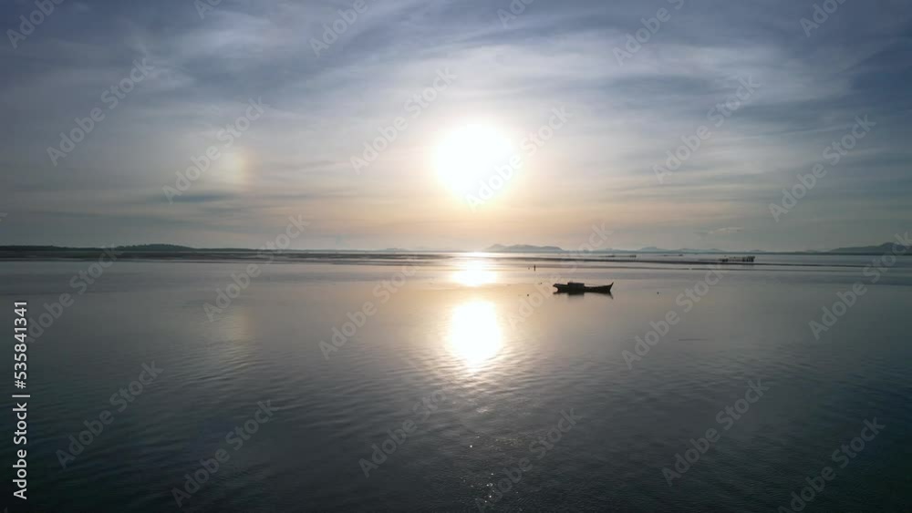 calm and flat ocean with boat on glassy water at sunrise as aerial drone flies past fast calm and flat ocean with boat on glassy water at sunrise as aerial drone flies past fast