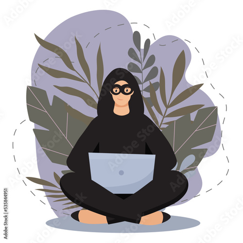 Hacker in a black mask with a computer