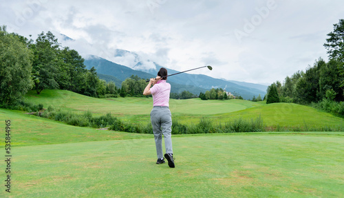 Woman golf player swinging golf club © xy