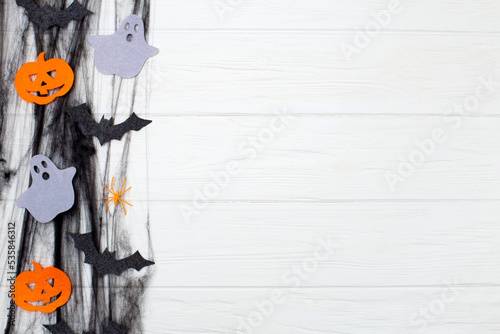halloween background. black web with spiders, halloween pumpkins, bats and ghosts on a white wooden background photo