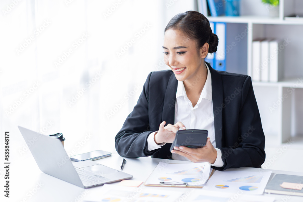 Asian female accountant or banker making calculations. Young business asian woman in workplace, Documents, tax, report for analysis Savings, finances and economy concept. Asian female accountant or banker making calculations. Young business asian woman in workplace, Documents, tax, report for analysis Savings, finances and economy concept.