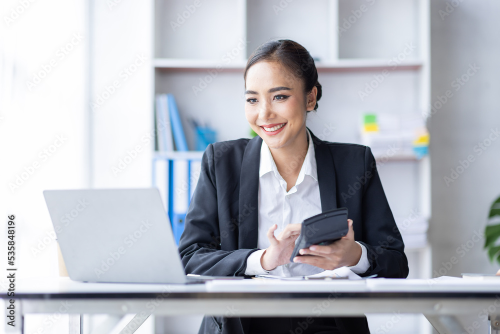 Asian female accountant or banker making calculations. Young business asian woman in workplace, Documents, tax, report for analysis Savings, finances and economy concept. Asian female accountant or banker making calculations. Young business asian woman in workplace, Documents, tax, report for analysis Savings, finances and economy concept.