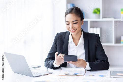 Asian female accountant or banker making calculations. Young business asian woman in workplace, Documents, tax, report for analysis Savings, finances and economy concept.