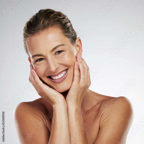 Skincare, face beauty and mature woman with smile for facial wellness against a grey mockup studio background. Portrait of an elderly luxury spa model happy about dermatology and cosmetics for body
