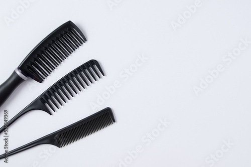 Three black hair combs. White background. Place text.