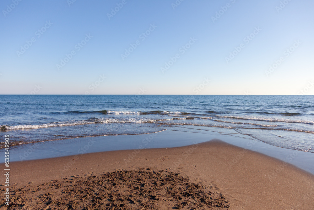 Panorama marino con cielo azzurro e mare con piccole onde.