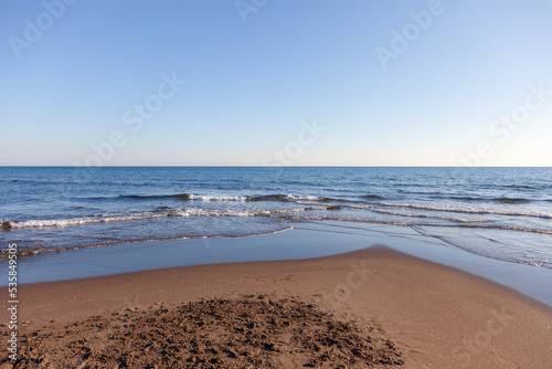 Panorama marino con cielo azzurro e mare con piccole onde.