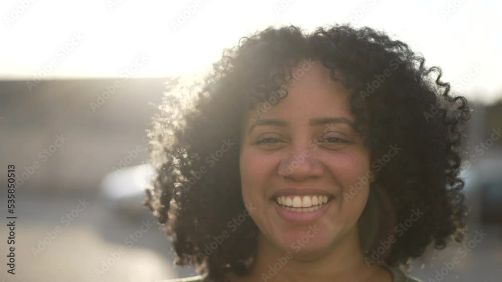 One happy black woman smiling at camera standing outdoor. Portrait face closeup of African American female person One happy black woman smiling at camera standing outdoor. Portrait face closeup of African American female person