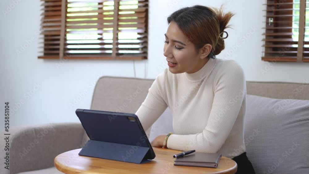 Young Asian woman using tablet at home. Young Asian woman using tablet at home.