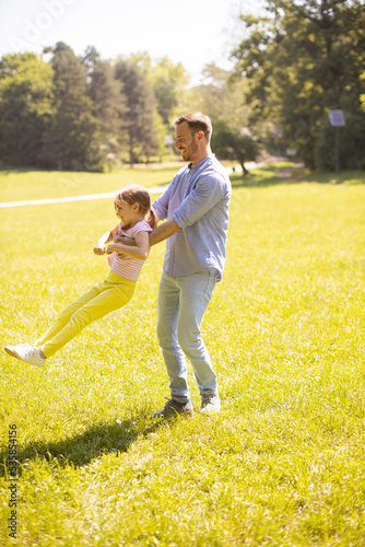 Father with daughter having fun on the grass at the park