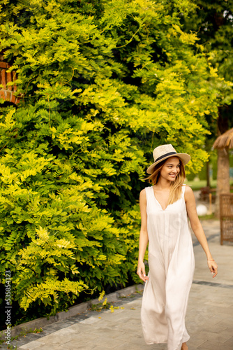Young woman with hat walkin...