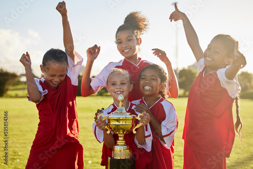 Fototapeta Naklejka Na Ścianę i Meble -  Children, football trophy and winning team of sports competition on soccer field for celebration of goal, win and teamwork after a match outdoors. Youth, kids or girls club after a tournament game