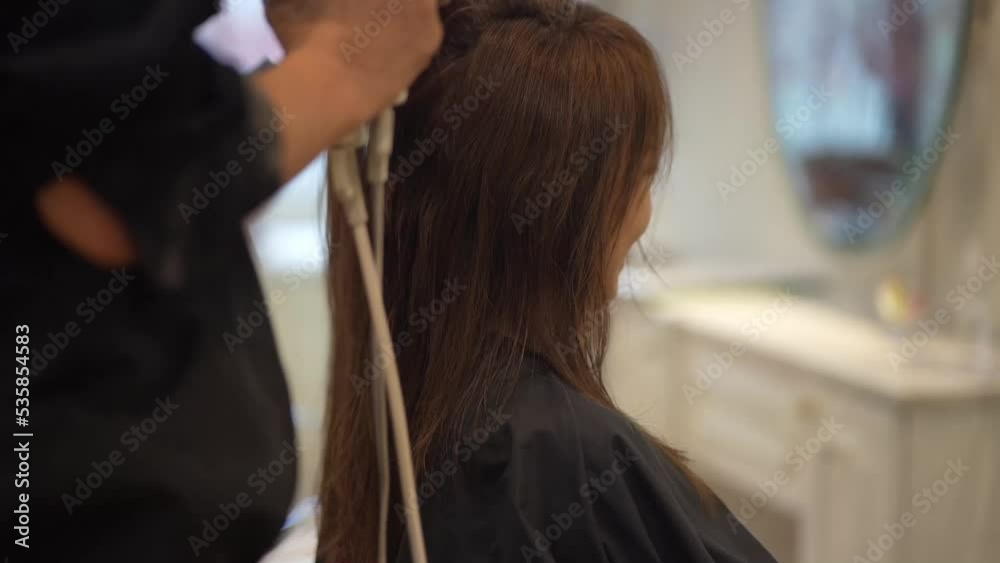 女性の髪にドライヤーをかける男性美容師 女性の髪にドライヤーをかける男性美容師