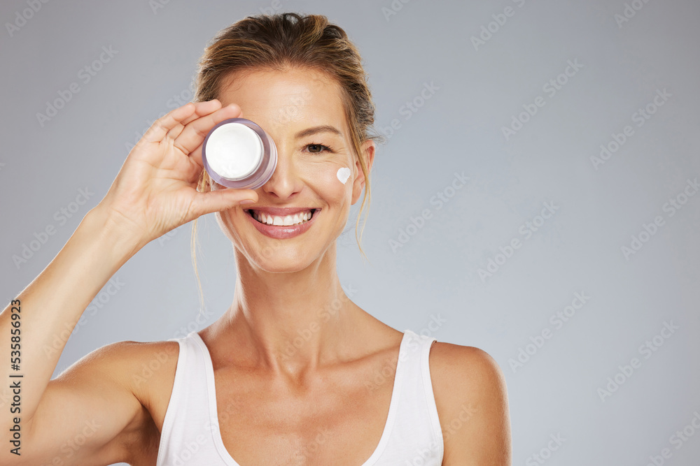 Beauty, skincare and product with a woman advertising or marketing antiaging skin treatment in studio on a gray background. Cosmetics, body and care with a beautiful mature female holding a container Beauty, skincare and product with a woman advertising or marketing antiaging skin treatment in studio on a gray background. Cosmetics, body and care with a beautiful mature female holding a container