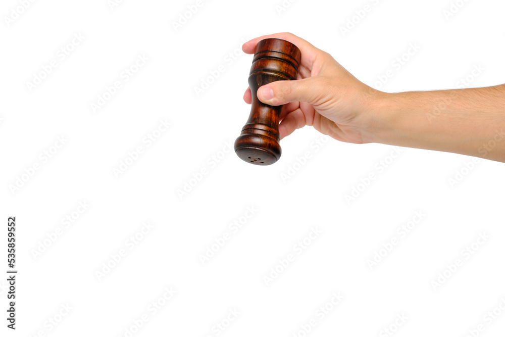 Wooden pepper pot in hand on a white background. Wooden pepper pot in hand on a white background.