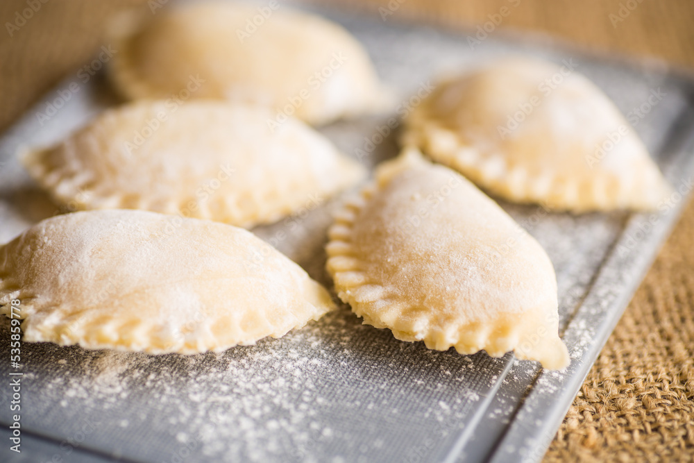 Raw dumplings . Dumplings cooking on a kitchen cutting board.