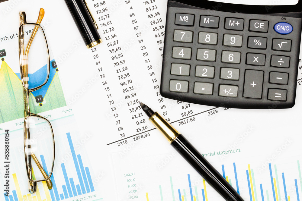 Top view office table desk. Financial report. Flat lay. Workspace with Business office supplies, Accounts number on the data paper, pen, glasses, calculator on the table. Top view. Close-up Top view office table desk. Financial report. Flat lay. Workspace with Business office supplies, Accounts number on the data paper, pen, glasses, calculator on the table. Top view. Close-up