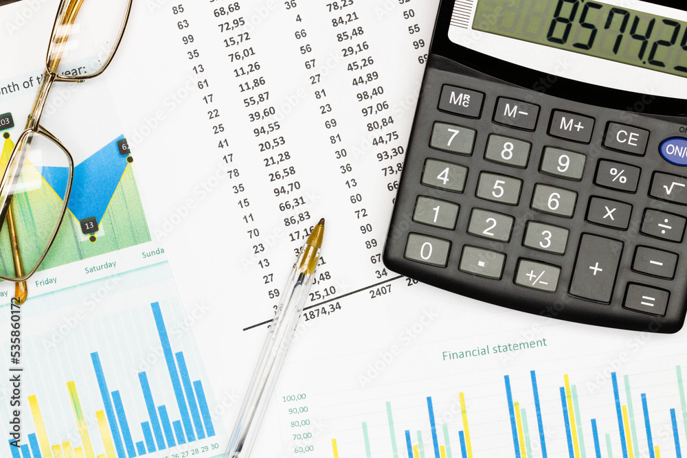 Top view office table desk. Financial report. Flat lay. Workspace with Business office supplies, Accounts number on the data paper, pen, glasses, calculator on the table. Top view. Close-up