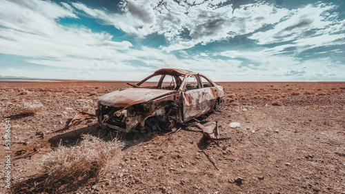 a burnt-out car in the desert. Burned abandoned car