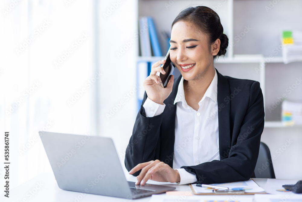 Beautiful Young business Asian Woman Talking on Smartphone in workplace Beautiful Young business Asian Woman Talking on Smartphone in workplace