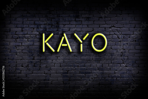 Konstfotografi Neon sign. Word kayo against brick wall. Night view