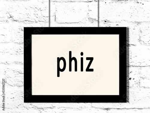 Black frame hanging on white brick wall with inscription phiz photo