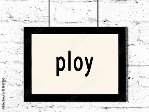 фотографія Black frame hanging on white brick wall with inscription ploy