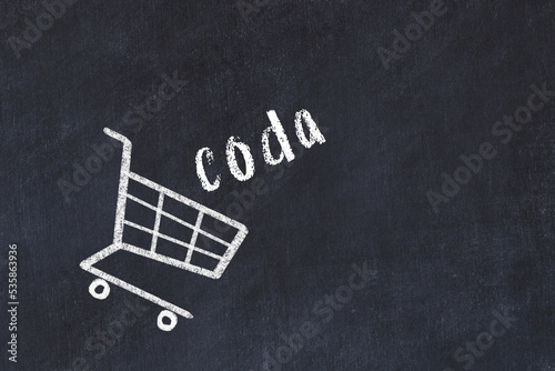 Chalk drawing of shopping cart and word coda on black chalboard. Concept of globalization and mass consuming