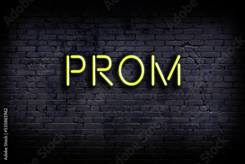 Neon sign. Word prom against brick wall. Night view photo