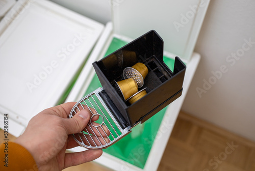 throwing coffee capsules in the trash bin