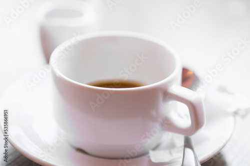 Defocused view of white cup of hot coffee